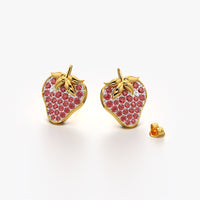 Gold strawberry-shaped earrings with red gemstones on a white background